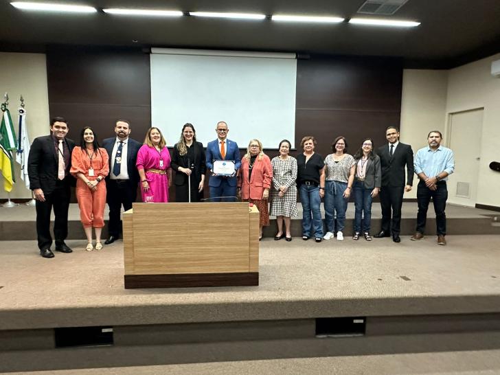 #ParaTodosVerem: Fotografia colorida em ambiente fechado mostrando o certificado do selo de linguagem simples, na foto está pres